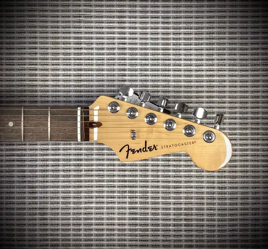 Fender Stratocaster headstock against amp grille cloth